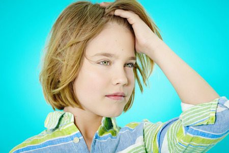 Ten year old boy posing on cyan background.の写真素材