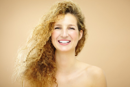 Happy smiling young woman with curly hair.