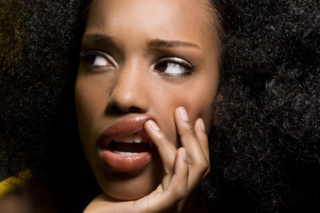 Beautiful dark model with little freckles and pensive expression.の写真素材