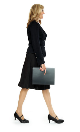 Confident middle-aged woman wearing dark suit and white blouse posing on white background.の写真素材