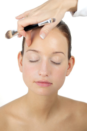 Young woman is getting her makeup. Professional makeup artist at work.の写真素材