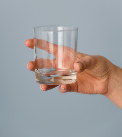 Female hand holding an empty glass.