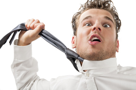 Young desperate business man with stress expression pulling his tie around neck.