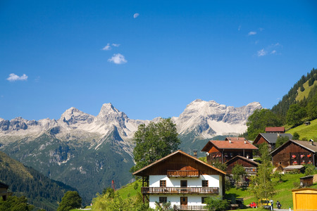 Scenic village in Tirol with majectic view of mountains, houses, blue sky and greens.の写真素材