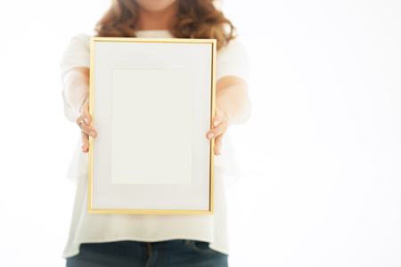 Woman holding blank golden art frame. の写真素材