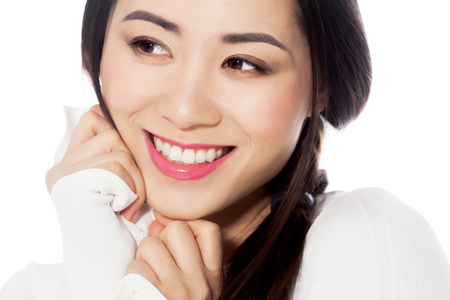 Beautiful casual young Asian woman portrait in white striped sweater on white background.の写真素材