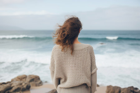 A woman by the coastline, her relaxed demeanor and casual clothing reflecting the essence of a laid-back beach vacation. The serene backdrop complements their peaceful atmosphere.の素材