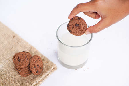 Chocolate cookies on a white table with milk