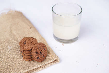 Chocolate cookies on a white table with milk