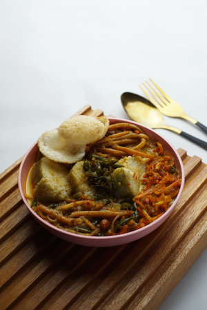 Lontong with curry soup accompanied by fried sweet potatoes chili sauce and noodlesの写真素材