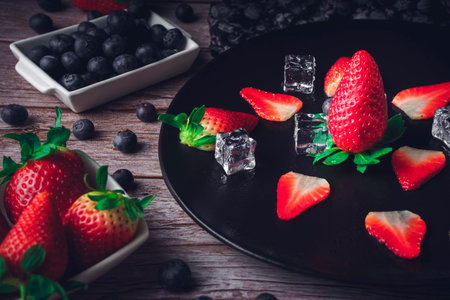 Still life of strawberry and blueberries. Dark food. Sweet dessert.
