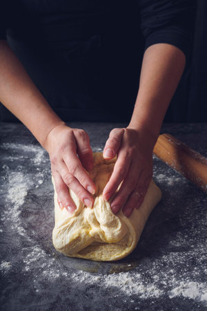 Women's hands kneading bread. Food background