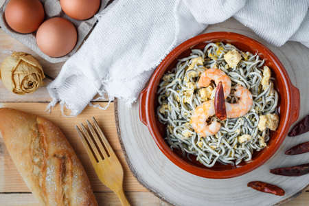 Top View Shrimp with egg and chilli cooking in clay casserole with olive oil. Mediterranean cuisine. Healthy foodsの写真素材