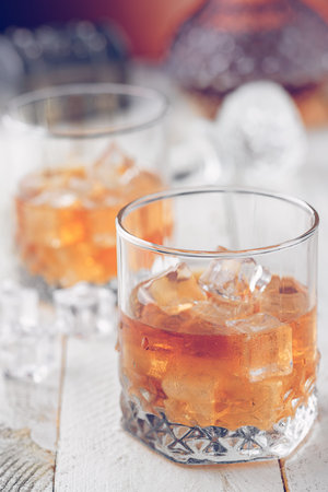 Two glasses of whiskey on a wooden bottom. Whiskey