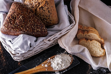 Bread with seeds on bottom with rag and wicker basket. Composition with bread and Wicker Basket....