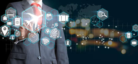 Businessman touching an icon plane as a business trip concept, travel planの写真素材