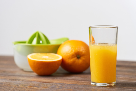 Freshly squeezed orange juice in a glass and fruit on a backgroundの写真素材