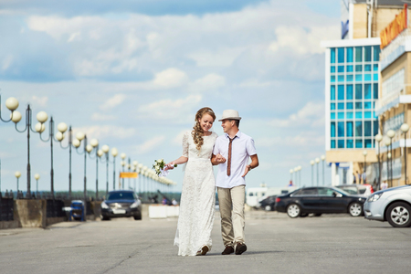 Bride and groom walking along the streetの写真素材