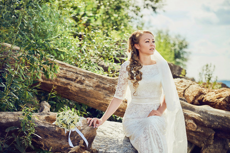 Bride sitting on a stone looking into the distanceの写真素材