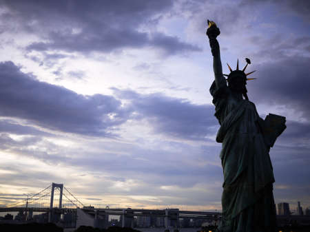 Statue of Liberty and rainbow bridge at Odaiba, Tokyo in sunset の写真素材