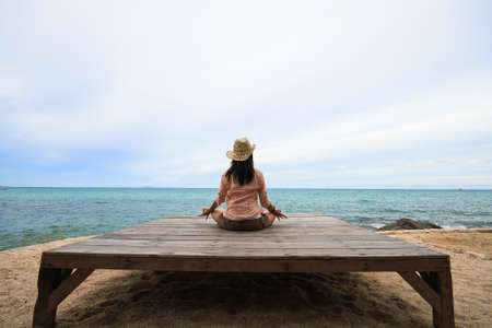 woman practices yoga on beachの写真素材