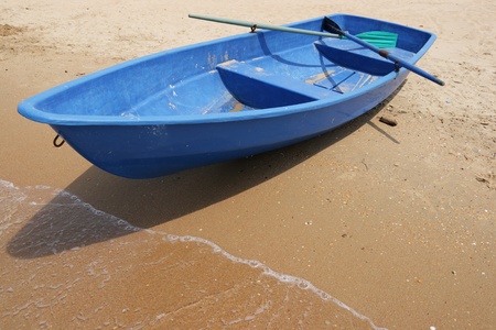Dark blue boat on a sandy beachの写真素材