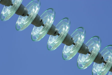 High-voltage electrical insulator electric line against the dark blue sky