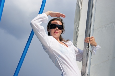 The girl costs on a yacht nose keeping for a sail during a stormの写真素材