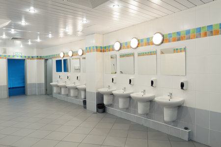 A row of washbasins with mirrors in a public toiletの写真素材