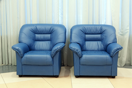 Two dark blue leather armchairs in a room interiorの写真素材