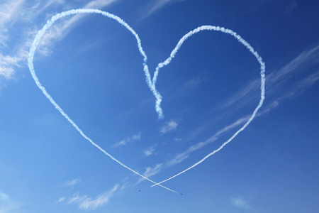 Two of the plane in the blue sky show figures of aerobatics - smoke painted heartの写真素材
