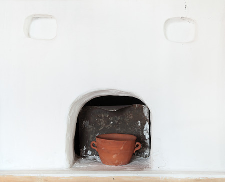 The old white russian furnace and a clay pot inside herの写真素材