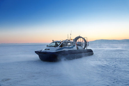 Hovercraft transport on the frozen lake Baikal at the time of sunset, Siberia, Russiaの写真素材