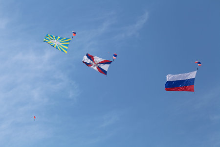 ZHUKOVSKY, RUSSIA - AUG 11: The opening ceremony of celebrating of the 100 anniversary of Russian air force of Russia. August, 11, 2012 at Zhukovsky, Russia. The paratroopers with flags in the skyのeditorial素材