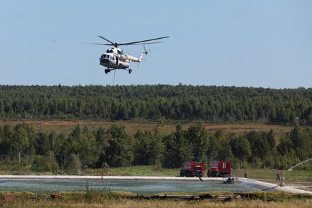 Fire helicopter draws up water from a fire reservoir for forest fire fightingのeditorial素材