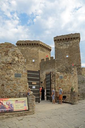 SUDAK, REPUBLIC OF CRIMEA, RUSSIA - AUG 07, 2014: The ruins of the medieval Genoese fortress in Sugdeya city (currently - Sudak). Tourists at the entrance gateのeditorial素材