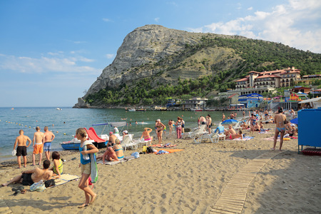 NOVYI SVIT VILLAGE, REPUBLIC OF CRIMEA, RUSSIA - AUG 07, 2014: View of the popular resort Novosvetskaya Bay and Mount Koba-Kaya. People relaxing on the beach.のeditorial素材