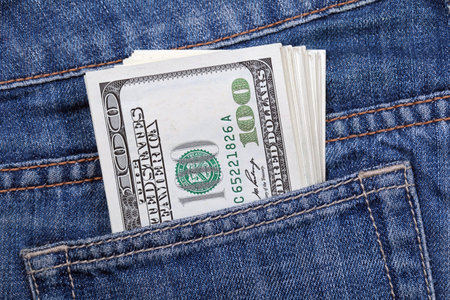 Stack of US dollars sticking out of his jeans pocket