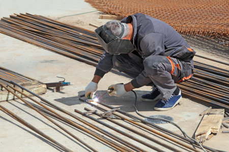Welder man weld metal rebar by electric welding at the construction site