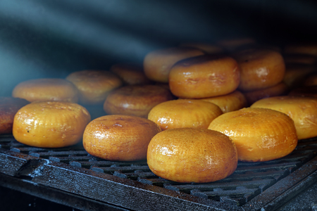 Smoked cheese is on the shelf in a smokehouseの写真素材