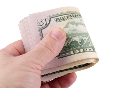 Stack of 50-dollar bills in hand, isolated on a white background