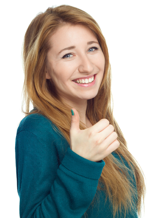 Young woman is showing thumb up gesture, isolated over whiteの写真素材