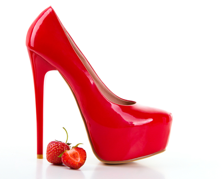 Red high heel women shoes with strawberry on white backgroundの写真素材
