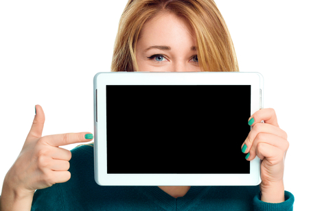 Young cheerful woman is showing blank tablet, isolated over whiteの写真素材