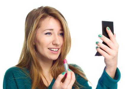 Closeup portrait of beautiful young woman with lipstick and mirror isolated on whiteの写真素材