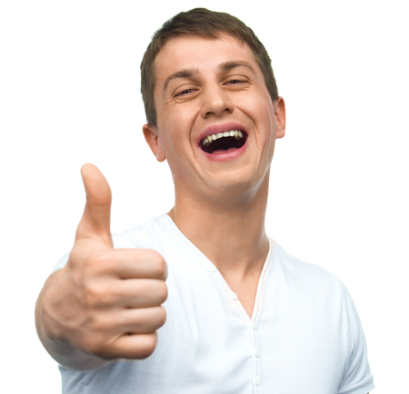Happy smiling guy showing thumb up hand sign isolated on white backgroundの写真素材