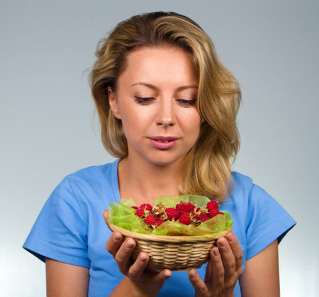 Close up of woman holding raspberriesの写真素材