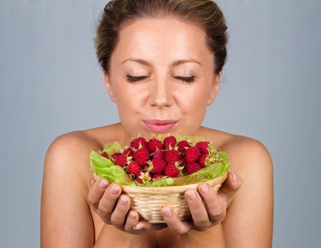 Close up of woman holding raspberriesの写真素材