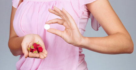 Woman hold on palm raspberries and tabletの写真素材