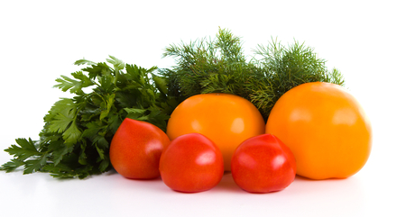 Red and yellow tomatoes with dill and parsley isolated on white backgroundの写真素材